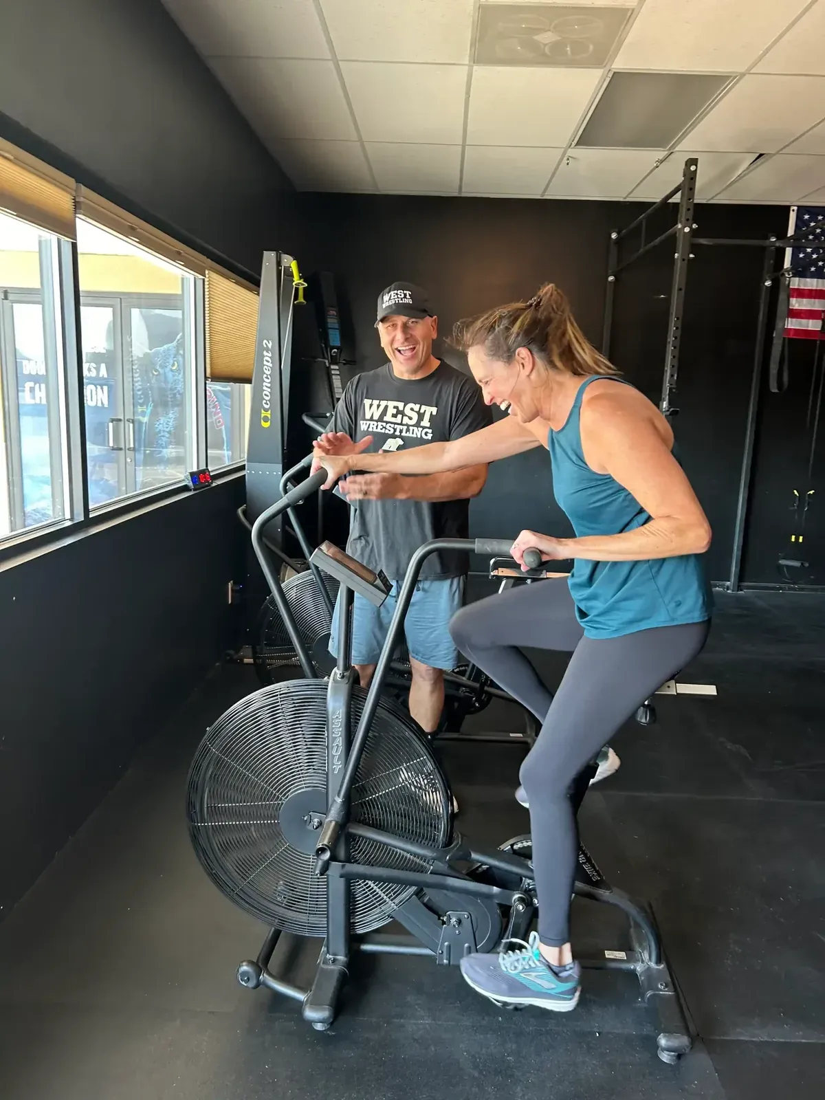 Corey Willis coaching a Knockout Lifestyle member through a bike interval