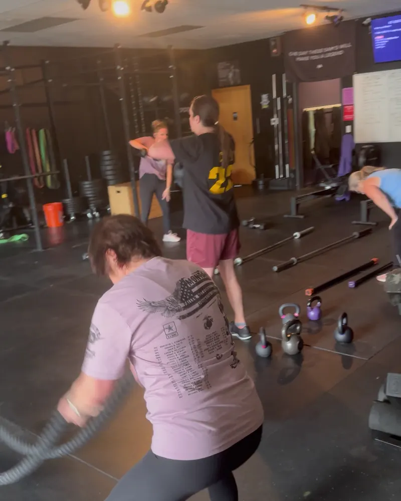 Members working battle ropes and kettlebells in a conditioning circuit at Knockout Lifestyle