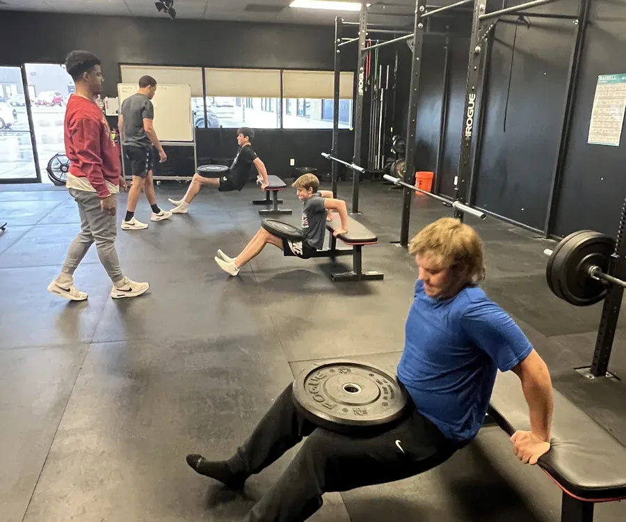 A small group working through weighted bench dips together
